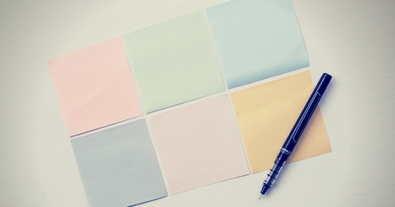 six blank sticky notes with a pen