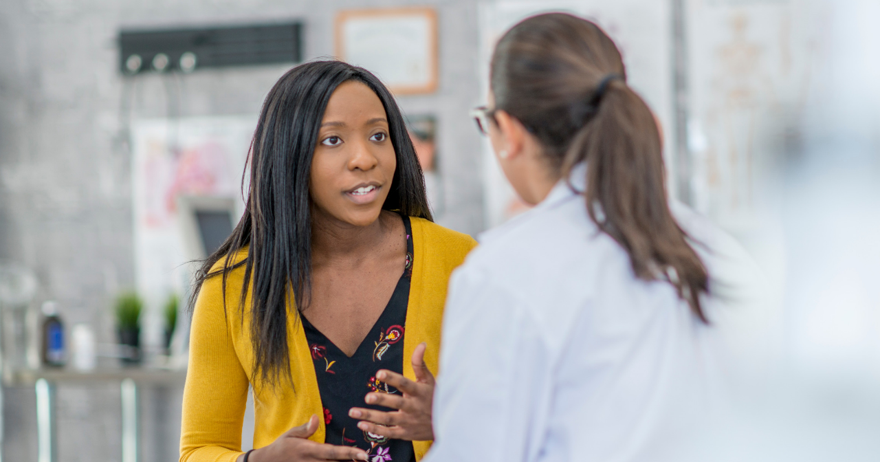 A woman and her provider talk in an exam room