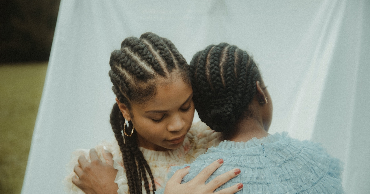 A photo of two sisters hugging gently. 