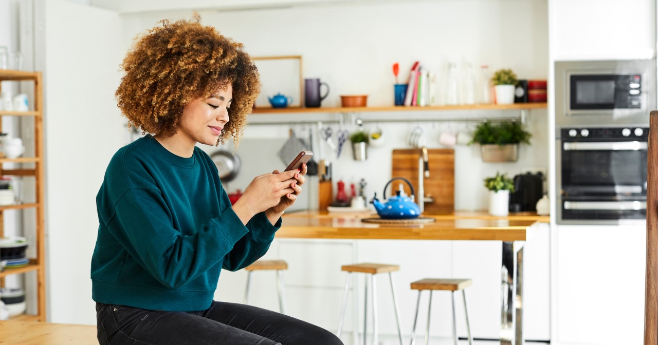 Woman on phone in her kitchen 