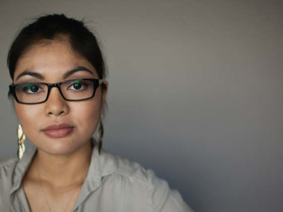 A woman looks very seriously into the camera