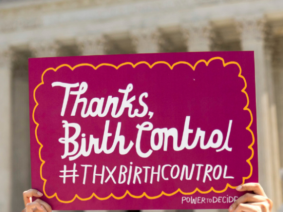 Hands holding a sign that reads, "Thanks, Birth Control #ThxBirthControl" outside the Supreme Court. 